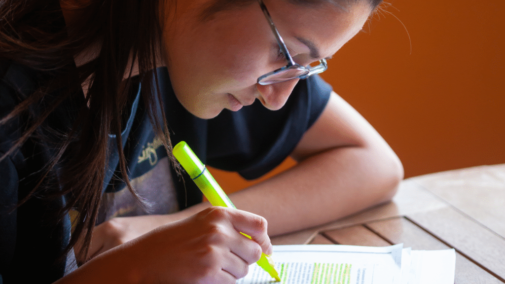 student highlighting important words on her textbook