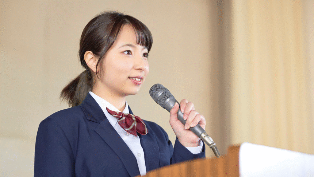 Image of a young girl confidently speaking in front of an audience.