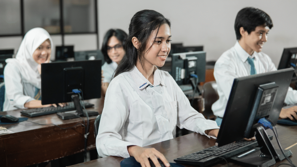 Students developing computer literacy skills while working on desktop computers in class.